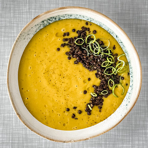 Kartoffel Lauch Suppe mit Belugalinsen und Lauchringen von oben vorne fotografiert