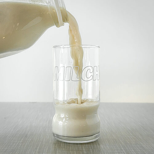 Selbsgemachte Hafermilch wird in ein 70er Vintage Milch-Glas eingegossen.