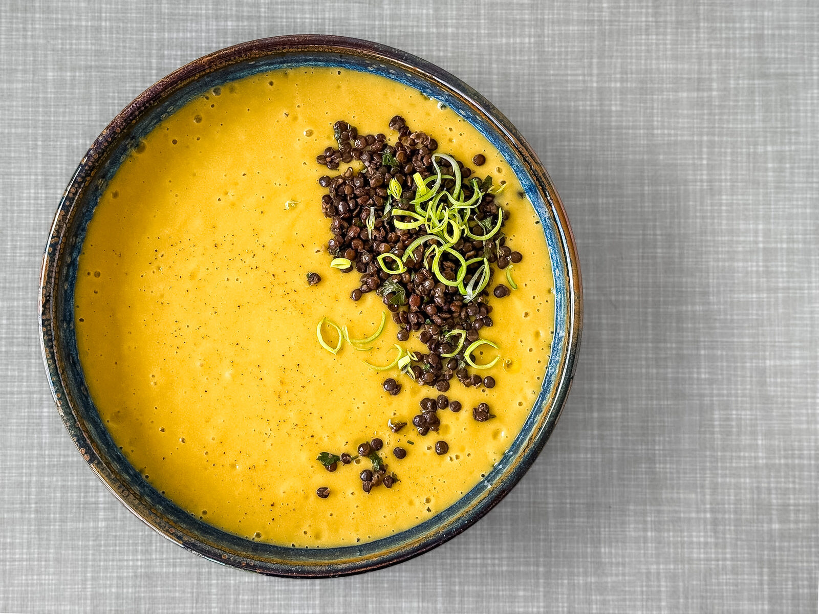 Kartoffel Lauch Suppe mit Belugalinsen und Lauchringen, von oben fotografiert