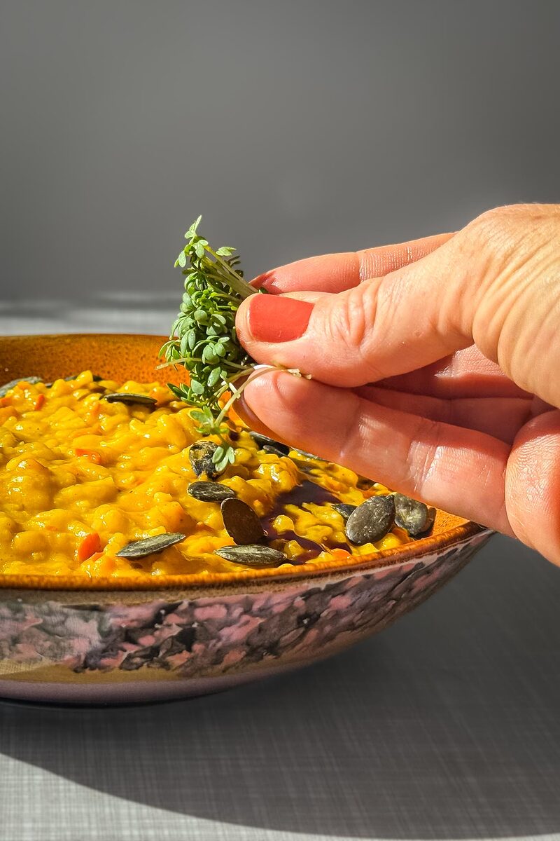 Kürbisrisotto wird mit Kresse verfeinert.